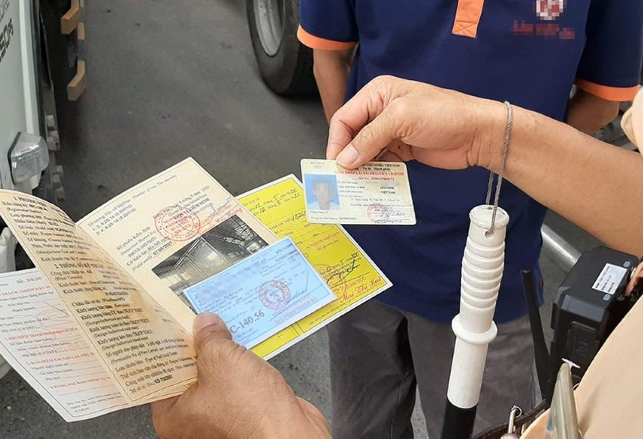 Người tham gia giao thông cầm giấy chứng nhận bảo hiểm